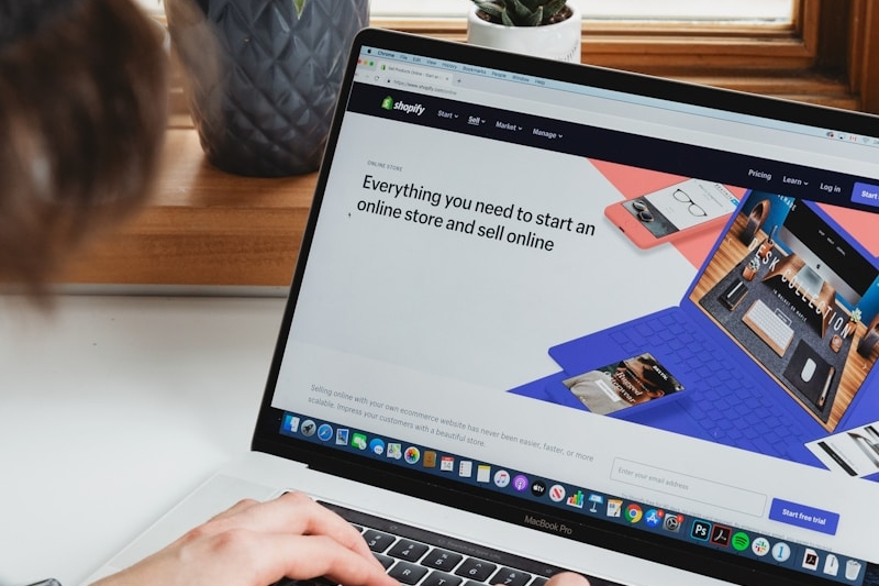 person using macbook pro on white table