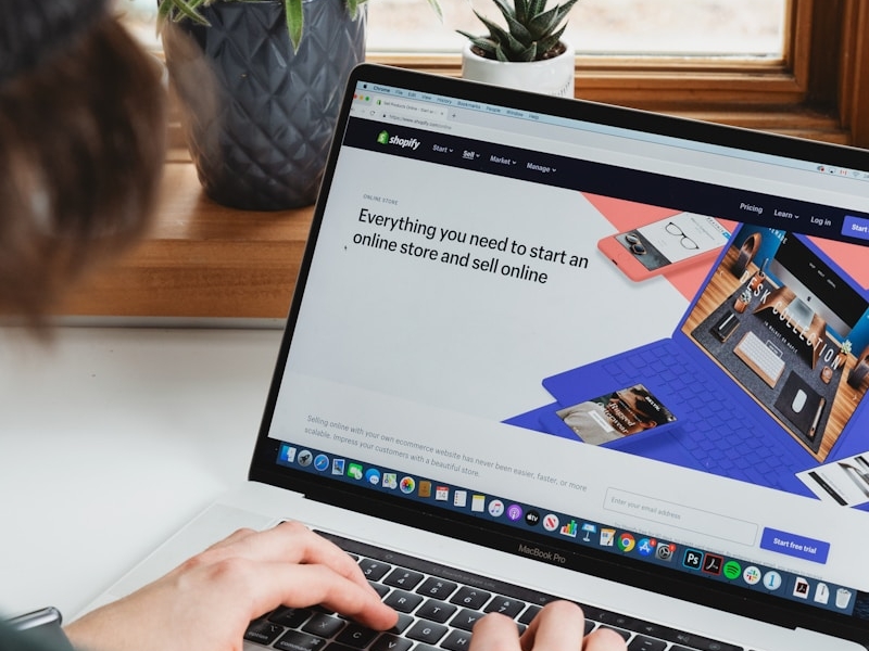 person using macbook pro on white table