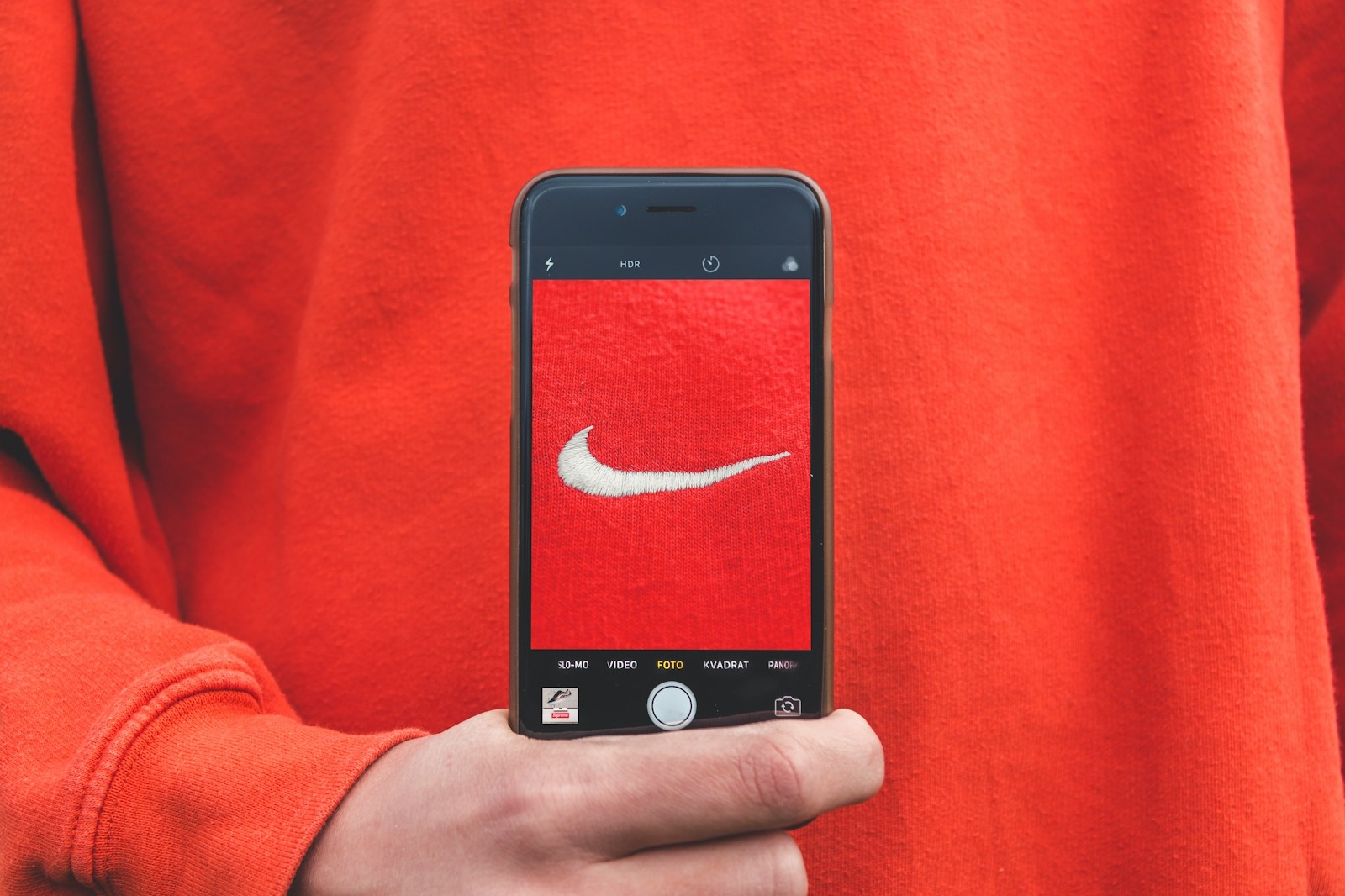 person holding iPhone taking picture on Nike label